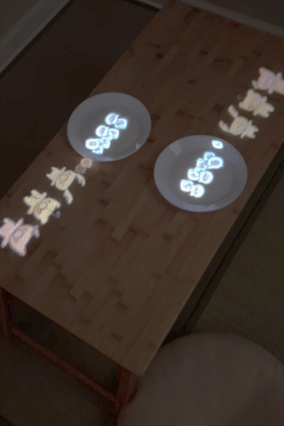 Animation of Bibi and friends inhaling shrimp dumplings projected onto a table